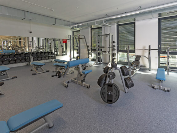 Zone de poids libre avec banc de musculation, rack à squats et haltères au studio ACTIV FITNESS de Genève Charmilles.