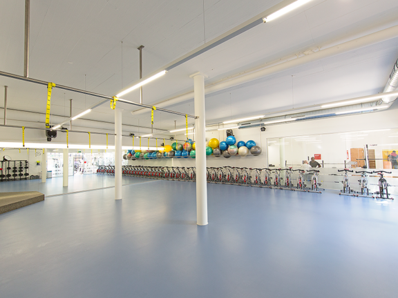 Classroom with spinning bikes and TRX sling trainers at ACTIV FITNESS Studio Corcelles