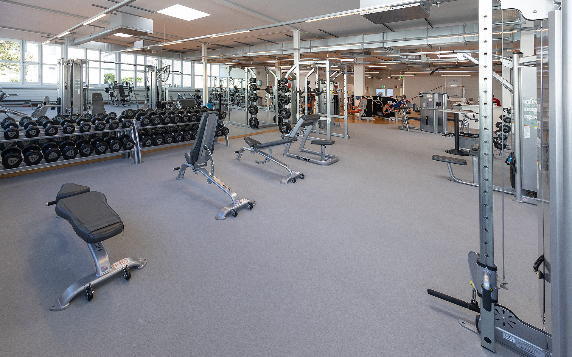 Free weight area with dumbbells, barbells and cable pulley in the ACTIV FITNESS studio in Gossau.