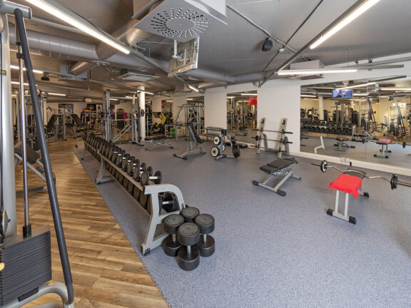 Free weight area with cable pulley, dumbbells and barbells at ACTIV FITNESS Studio Geneva ICC