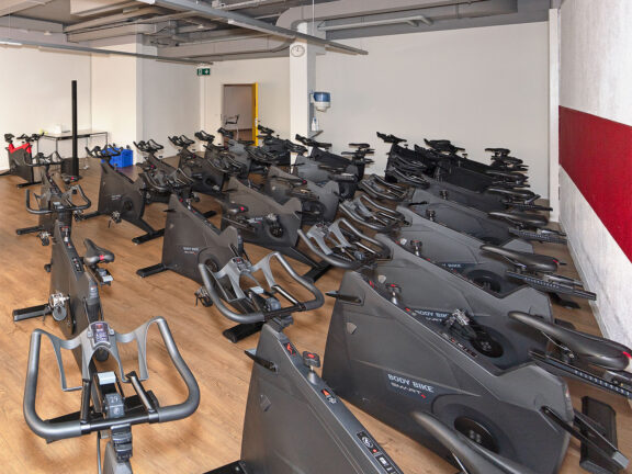 Salle de classe avec de nombreux vélos de spinning chez ACTIV FITNESS Studio Geneva ICC